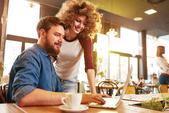 Male and female looking on laptop