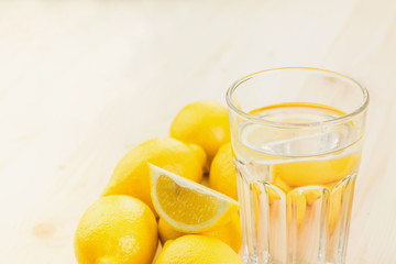 Glass of water with piece of lemon or fresh hand made lemonade