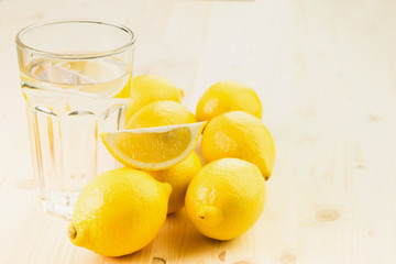 Glass of water with piece of lemon or fresh hand made lemonade