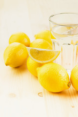 Glass of water with piece of lemon or fresh hand made lemonade