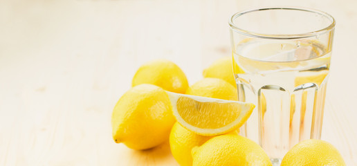Glass of water with piece of lemon or fresh hand made lemonade