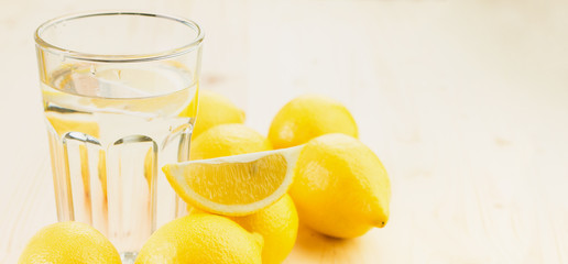 Glass of water with piece of lemon or fresh hand made lemonade