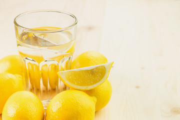 Glass of water with piece of lemon or fresh hand made lemonade