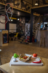 Sausages with beans on a wooden board with fresh vegetables