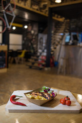 Grilled chicken breast with fries on a wooden board with fresh vegetables