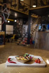 Grilled chicken breast with fries on a wooden board with fresh vegetables
