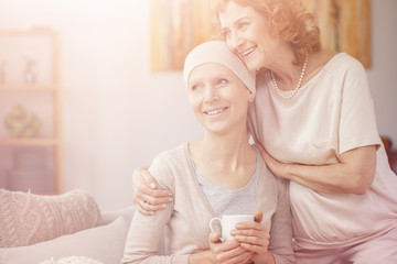 Bright photo of two positive senior woman sitting together at home enjoining their time after...