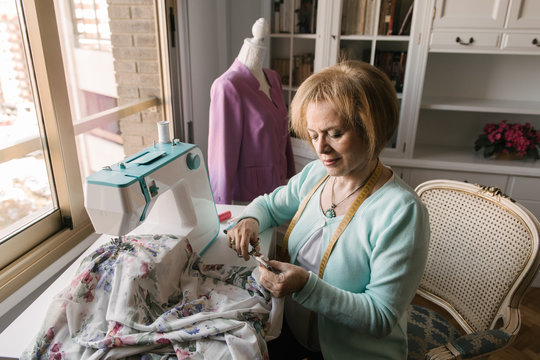 Senior woman using sewing machine