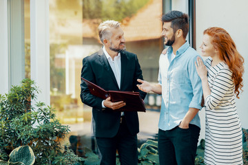 Smiling man and woman talking with financial advisor about house loan