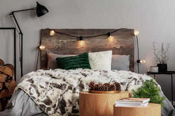 Christmas bedroom design with lights, spruce and cones