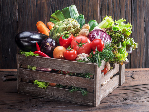 Fototapeta Fresh multi-colored vegetables in wooden crate. Wooden background.