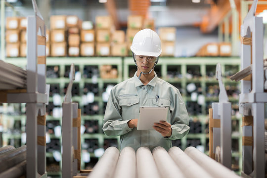 タブレットPCを操作する作業服の男性