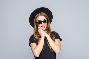 Portrait of beautiful girl in hat and sunglasses on gray background