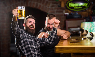 Refreshing beer concept. Men drinking beer together. Hipster brutal man drinking beer with friend at bar counter. Men drunk relaxing having fun. Alcohol drinks. Friends relaxing in pub with beer