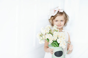 girl holding narcissus in hands. Adorable smiling little girl holding flowers for her mom on mother's day.