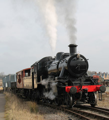Fototapeta na wymiar A Vintage Steam Engine Pulling a Goods Freight Train.