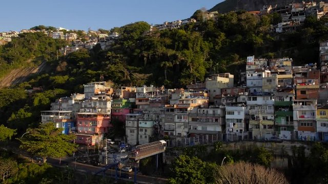 Aerial drone panning shot of hillside favela houses at sunrise