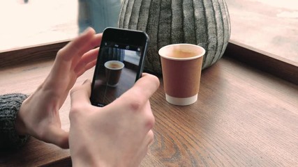 Man takes photos on mobile phone at cafe