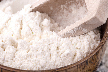 Fototapeta na wymiar The Wheat white flour in wooden cooking bowl with wooden spoon