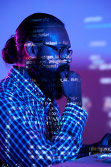 Double exposure shot of serious bearded programmer and reflection of coded data on monitor