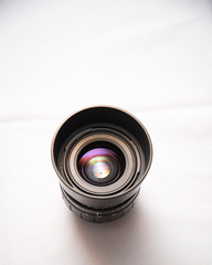 Photo lens from a SLR camera with beautiful colored glare on lenses on a bright background