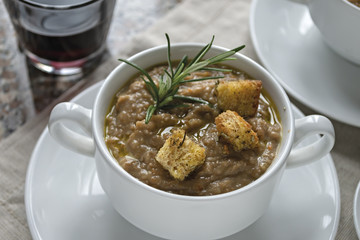 crema di lenticchie in tazza con bicchiere di vino rosso