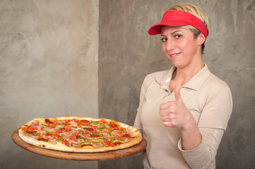 Female chef remove fresh italian pizza from stove