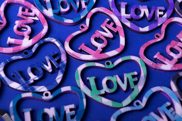  Multicolored hearts with the inscription LOVE, on a blue background, flat lay.Valentine's day holiday concept.