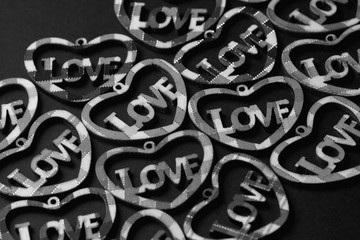 Wooden  hearts with the inscription LOVE, on a black background, flat lay.Valentine's day holiday concept.Black and white photography.