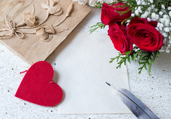 paper and pen to write love messages with book and roses