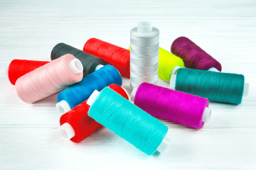 Many colorful threads lying on white table