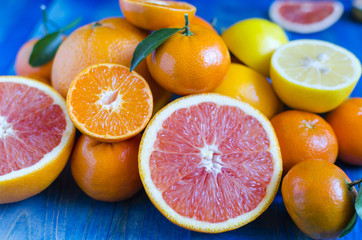 Citrus tangerines oranges lemons lime close-up on blue background