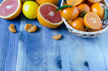 Obraz na płótnie Canvas Citrus tangerines oranges lemons lime close-up on blue background