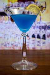Blue Kamikaze cocktail in martini glass decoreted slice of lemon