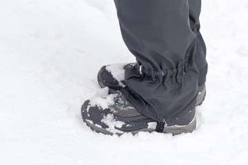 Women's legs in gray shoes and uppers in snow