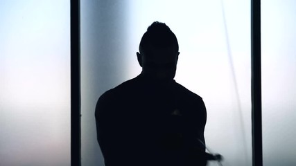 Young fit African American male jumping rope in gym