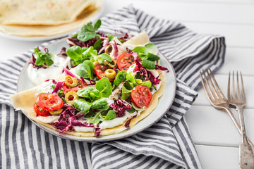 hearty pancakes with fresh salad, tomato and radicchio