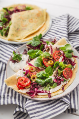 hearty pancakes with fresh salad, tomato and radicchio