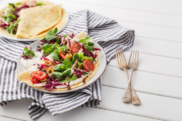 hearty pancakes with fresh salad, tomato and radicchio