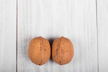 two whole walnuts on wooden background, healthy brain food, walnut on light vintage table
