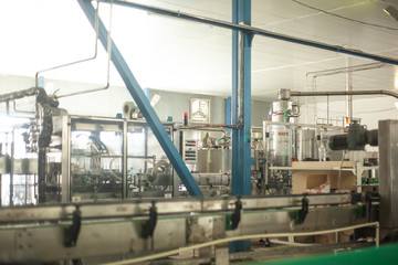 Glass bottles on the automatic conveyor line at the champagne, beer or wine factory. Plant for bottling alcoholic beverages.