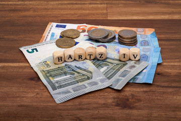 Die Euro Geldscheine und Münzen liegen auf dem Tisch mit dem Wort Hartz IV