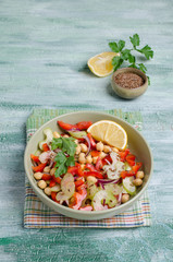 Raw vegetable salad with chickpeas and flax seeds on wooden background. Selective focus.