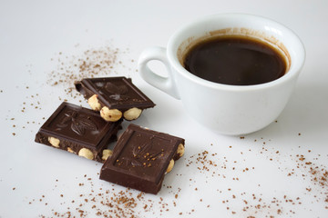 chocolate cubes with hazelnuts and a cup of coffee
