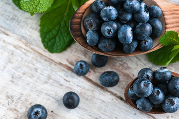 blueberries and various forest fruits, raspberries, strawberries. There are different types of wood on the table.