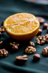 Close up of orange fruit and nuts on green background