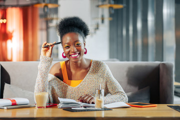 Curly student feeling excited and positive while studying