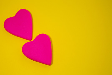 two pink hearts on a yellow background
