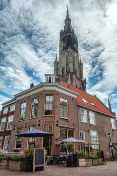 Restaurant on the corner of Oudemanssteeg in Delft with in the background the church tower of De Nieuwe Kerk.