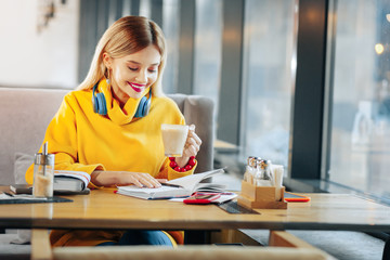 Woman looking into her daily planner sitting in cafeteria